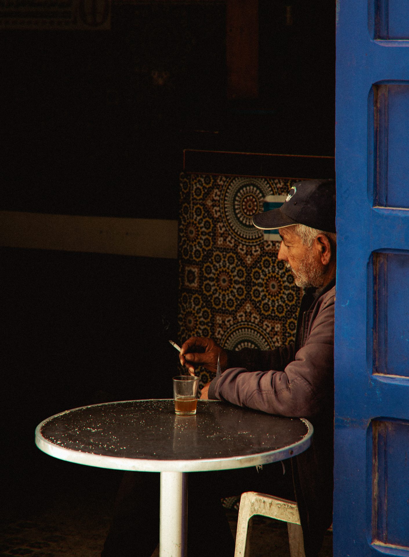 Un homme fumant sa cigarette avec un thé marocain
