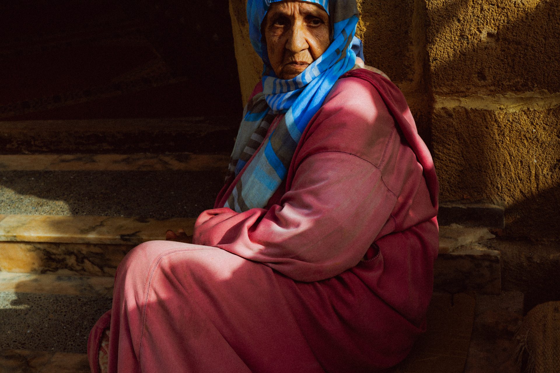 Une femme au voile bleu me regarde.