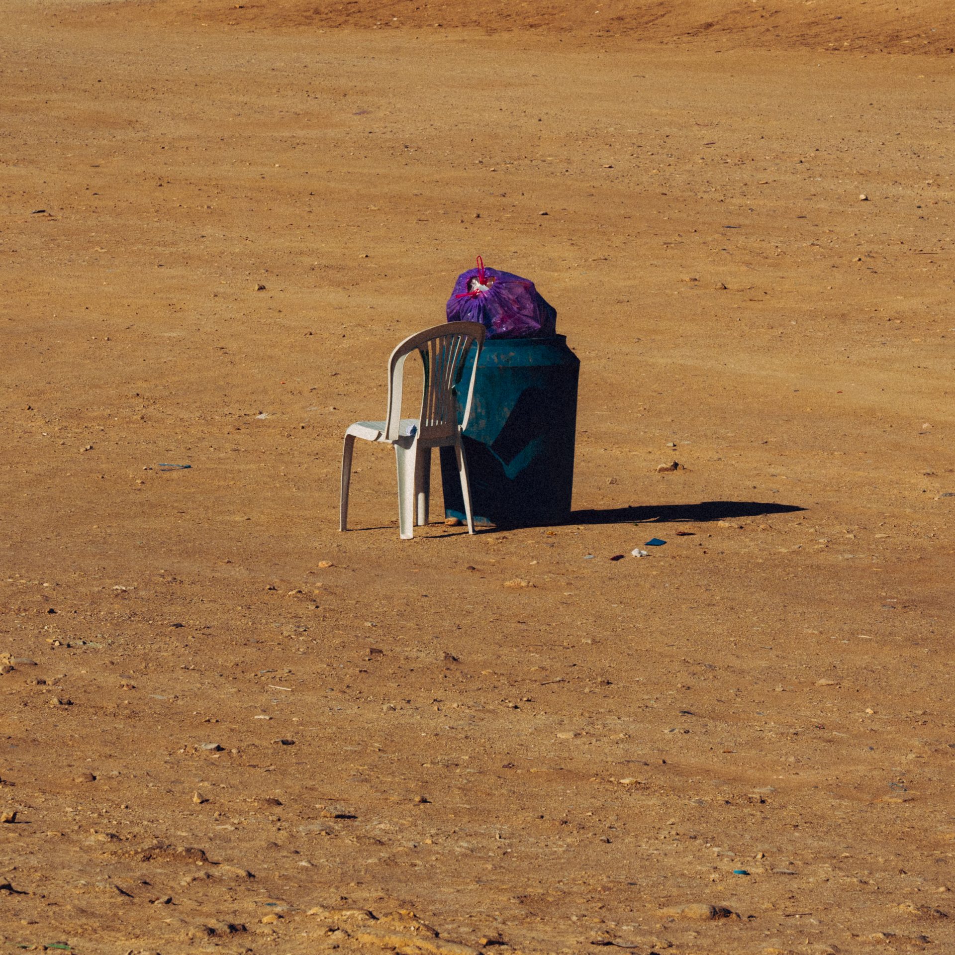 Une chaise et une poubelle remplie.